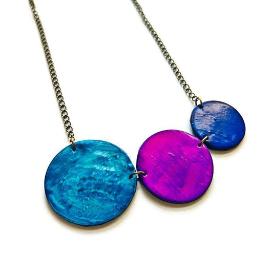 Necklace with three colorful circular pendants on a white background