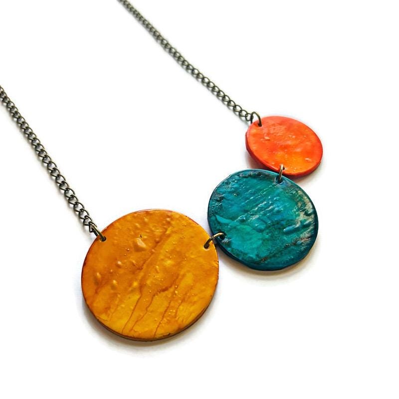 Necklace with three colorful circular pendants on a white background