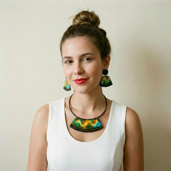 Woman wearing colorful earrings and a necklace against a plain background