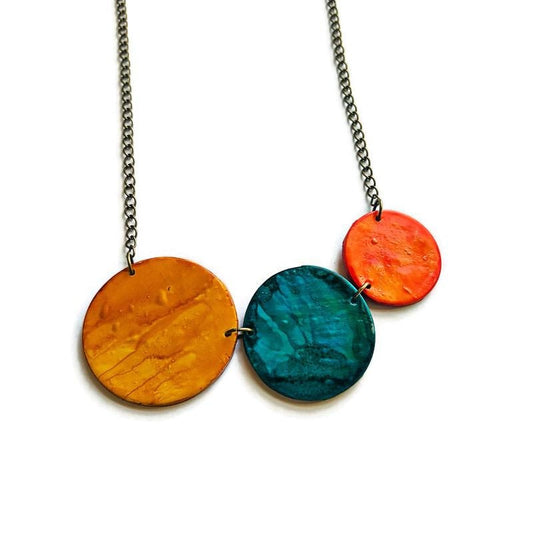 Necklace with three colorful circular pendants on a white background