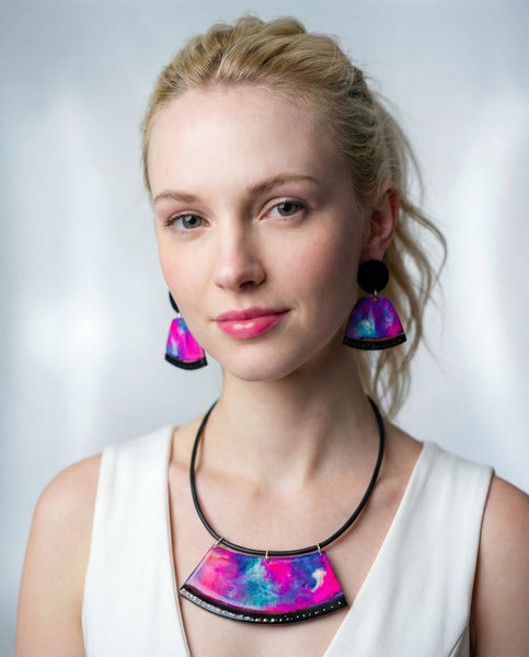 Woman wearing colorful necklace and earrings against a light background