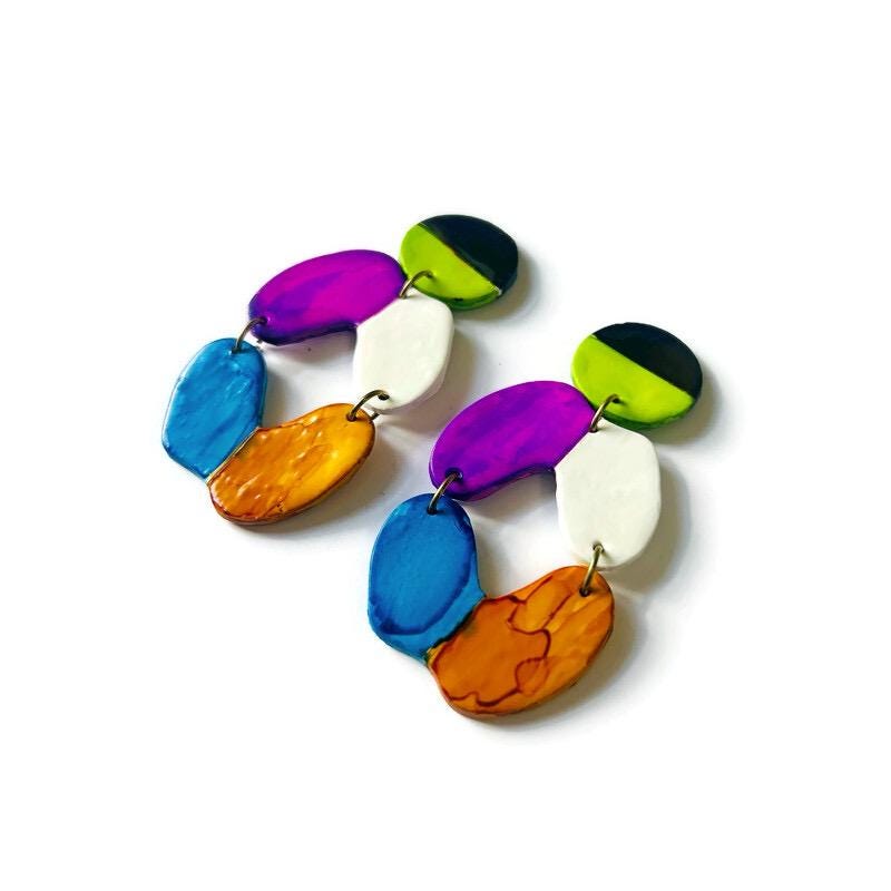 Colorful handmade earrings with stripes on white background