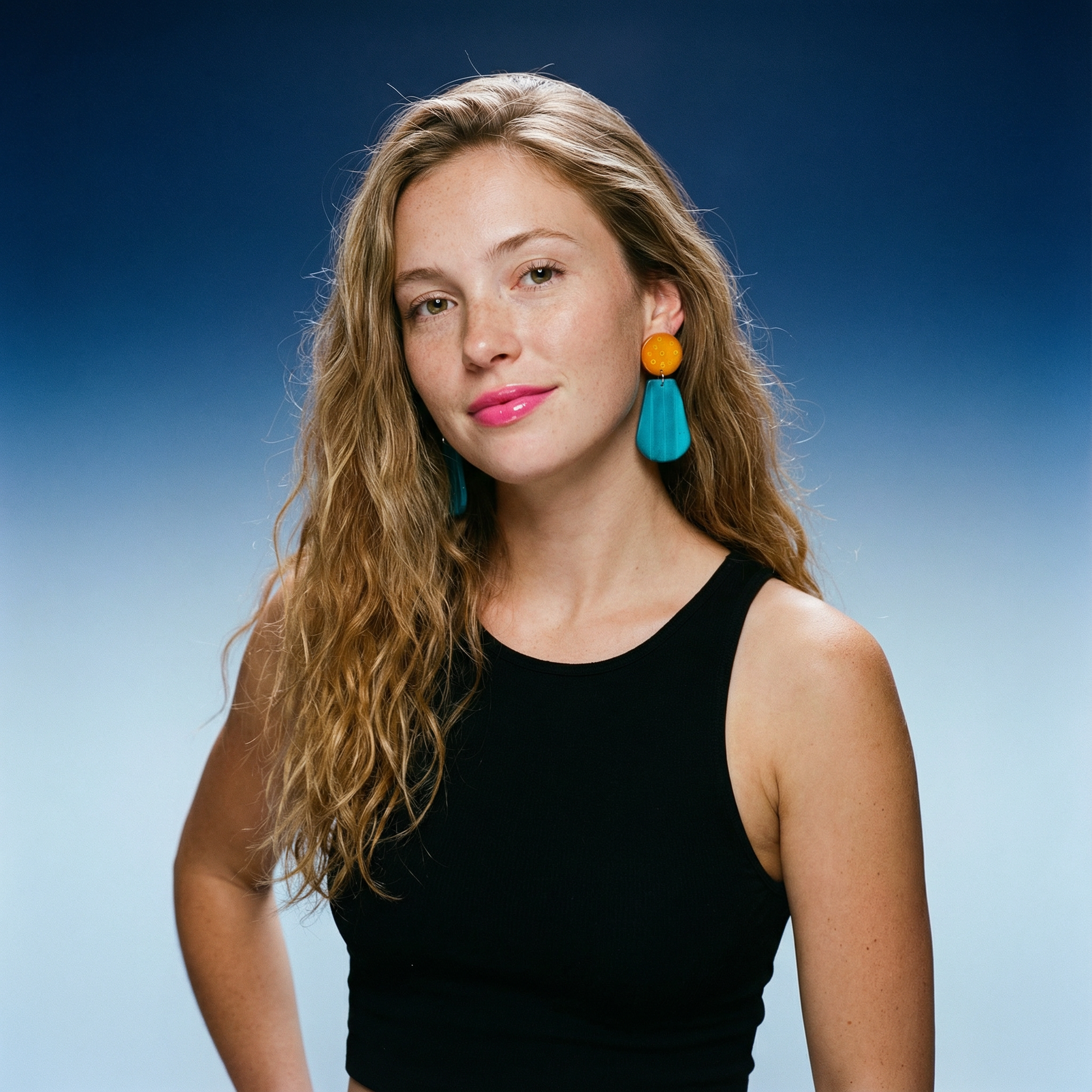 Woman wearing colorful earrings against a blue gradient background